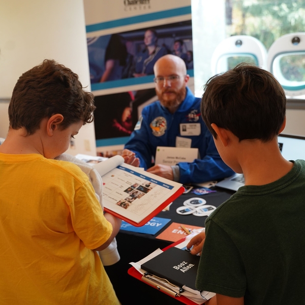 Students at The Siena School talk with a science educator from the Challenger Center during a Career Fair.