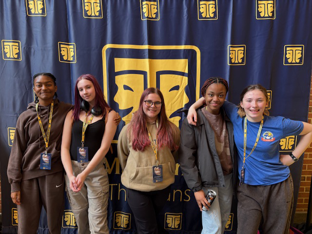 Five high school girls stand in front of a banner that says Maryland Thespians. They are very happy.