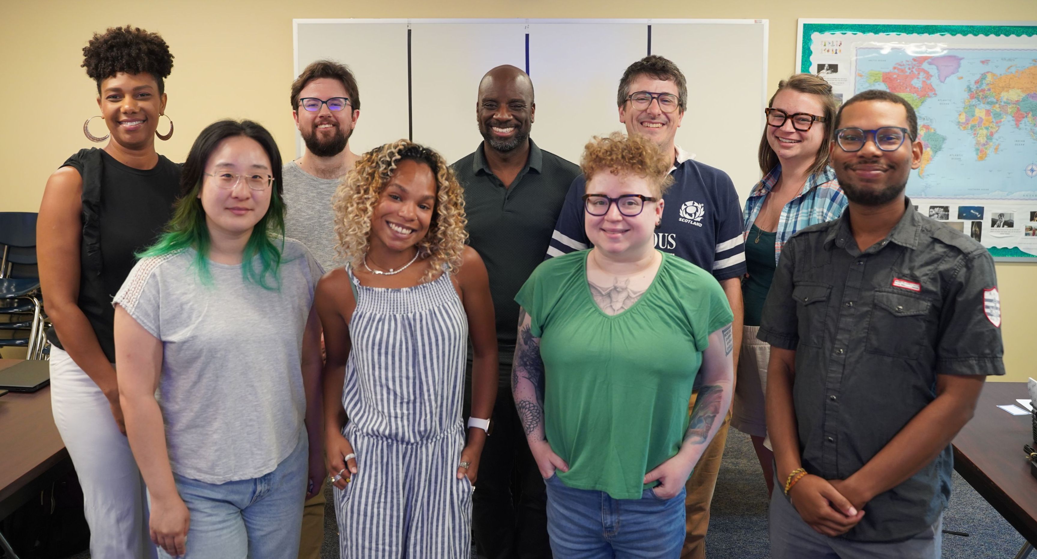 Nine people in two rows smiling at the camera.